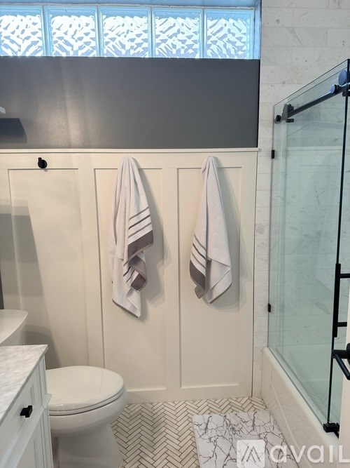 Two towels are hanging on a towel bar in a bathroom.