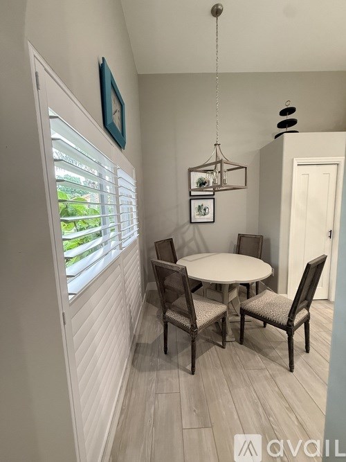 A dining room with a table and chairs.