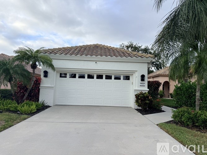 A white garage door is the centerpiece of this residential property.