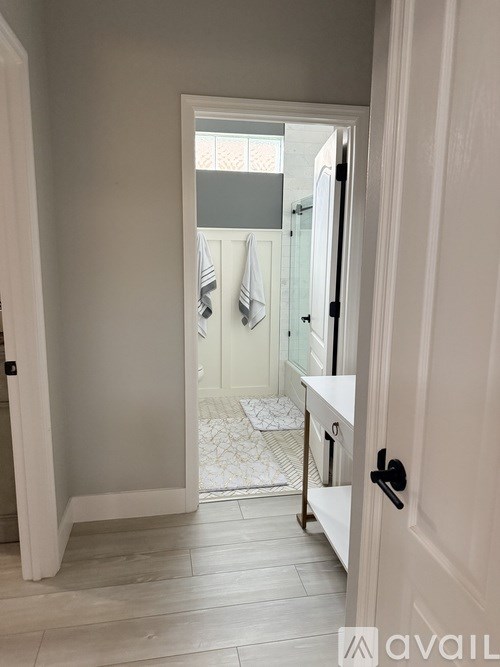A bathroom with a white door and a white mat on the floor.