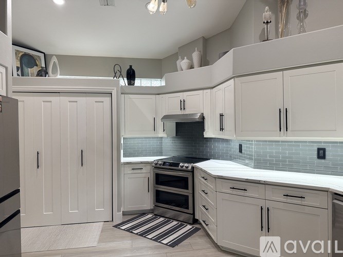 A kitchen with white cabinets and a black and white striped rug.