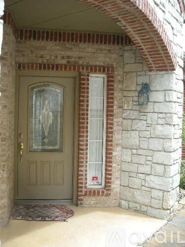 A door with a glass window is in a stone building.