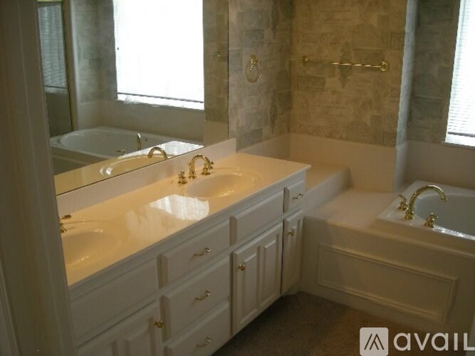 A bathroom with a tub, sink, and mirror.