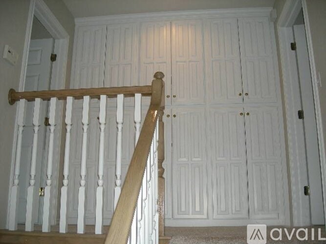 A white wooden staircase with a wooden handrail.