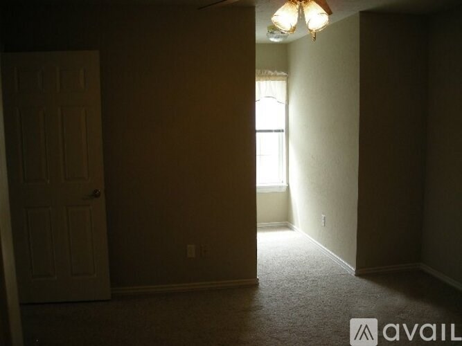 A room with a door and a window with a light on.