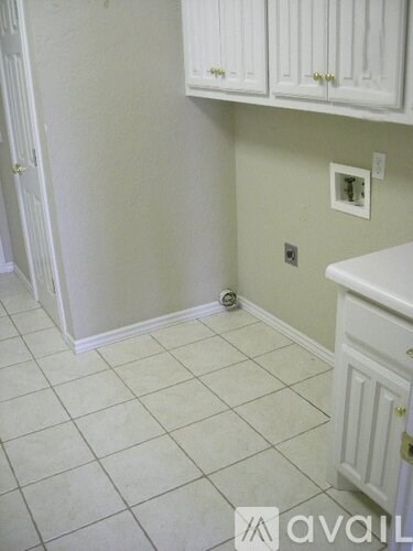 A kitchen with white cabinets and a tiled floor.