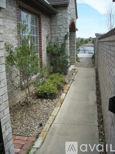 A grey house with a small garden in front.