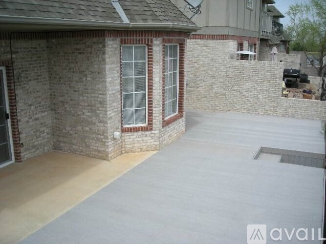 A house with a brick wall and a concrete driveway.