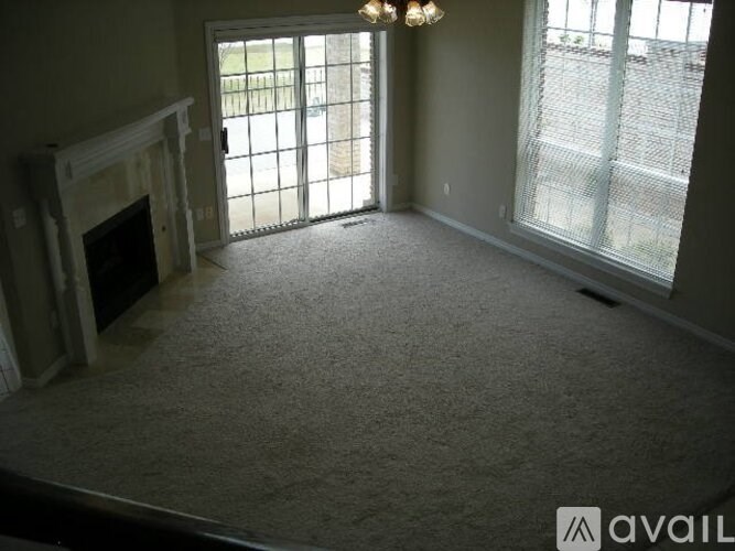A room with a fireplace and a carpeted floor.