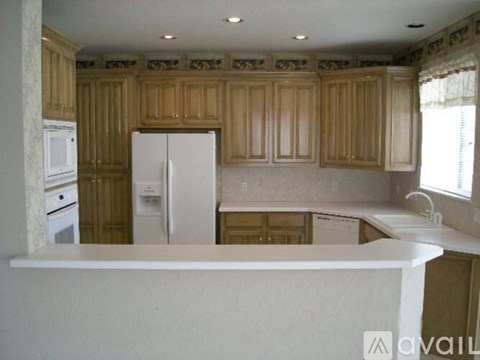 A kitchen with wooden cabinets and white appliances.