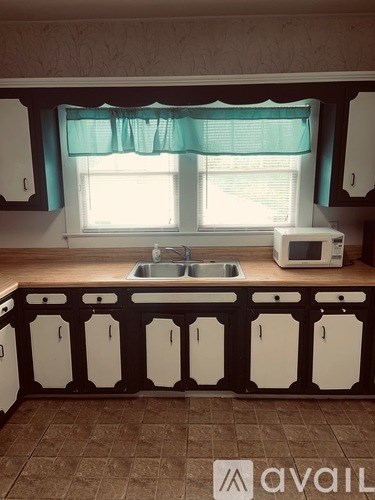 A kitchen with white cabinets and a brown floor.