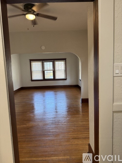 A room with wooden floors and a ceiling fan.
