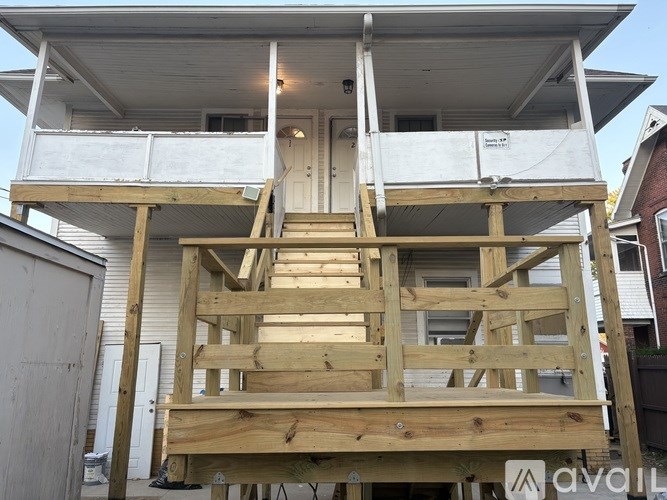 A wooden deck is being built on the upper level of a house.