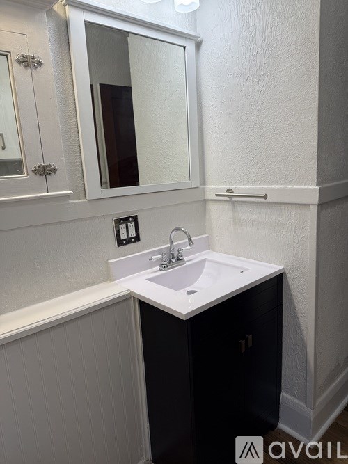 A bathroom with a sink and a mirror.