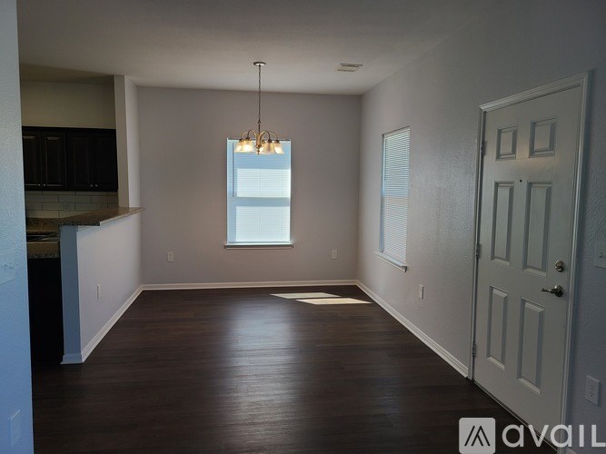 A room with wooden floors and a chandelier hanging from the ceiling.