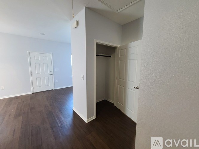 A room with a white door and a brown floor.