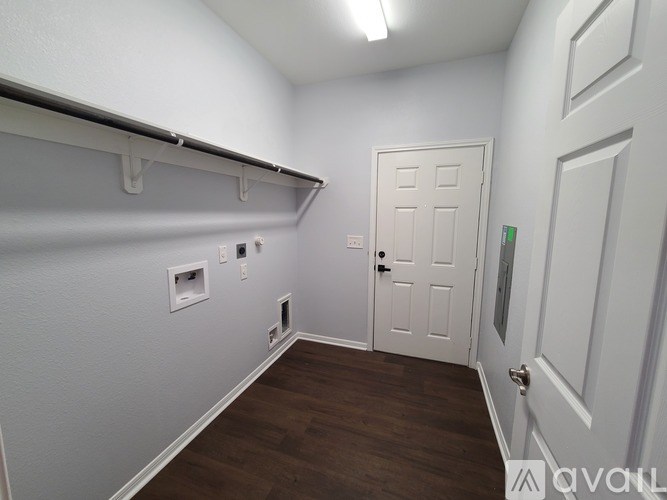A white door is in a room with wood floors and white walls.