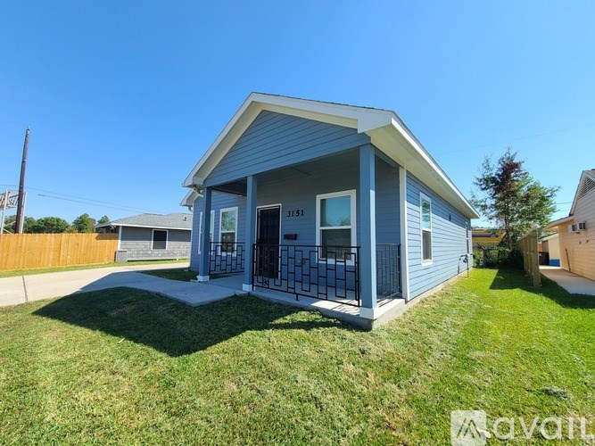 A blue house with a white roof and a black gate.
