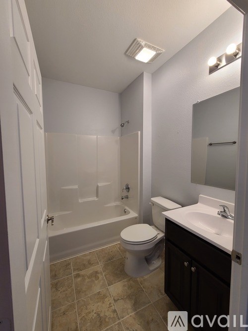 A bathroom with a toilet, sink, and bathtub.