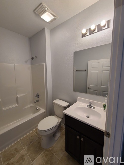 A bathroom with a toilet, sink, and bathtub.
