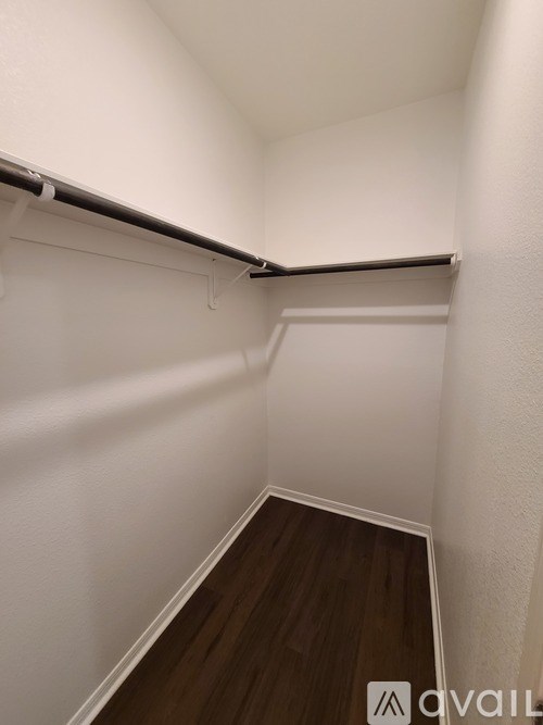 A small, empty room with white walls and a wooden floor.