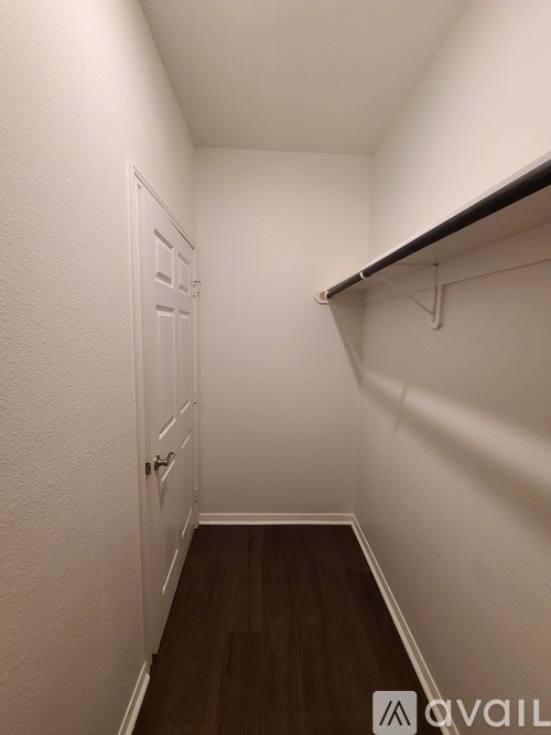 A hallway with a white door and a black shelf.