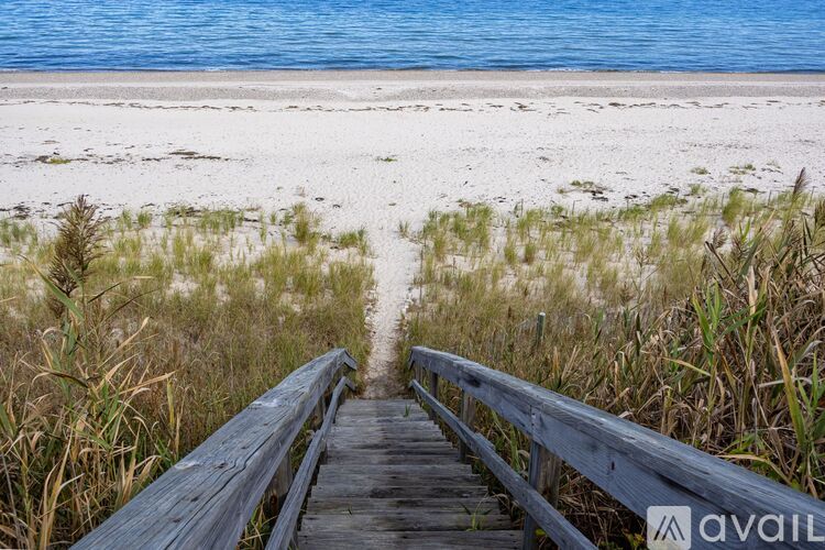 A wooden walkway leads to a beach.