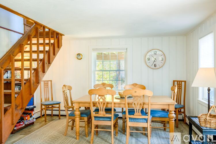 A dining room with a wooden table and chairs.