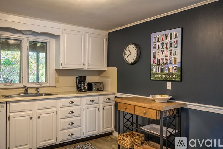 A kitchen with white cabinets and a wooden table.
