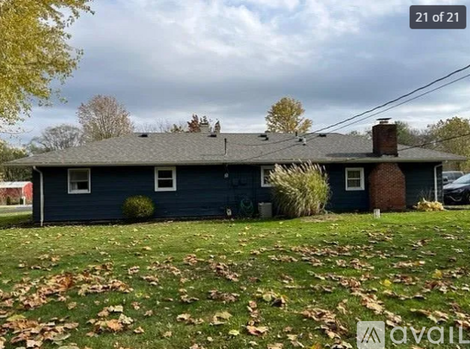 A house with a blue exterior and a grey roof with a chimney.
