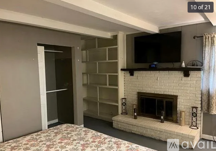 A living room with a fireplace and a television mounted above it.