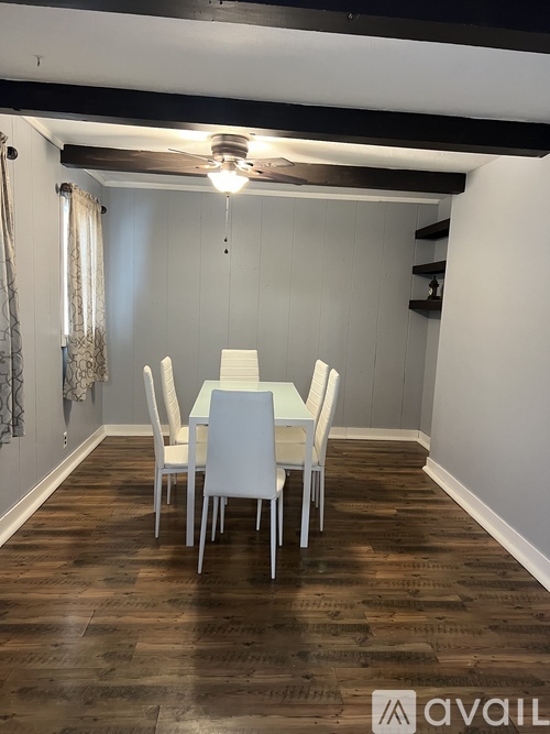 A dining room with a table and chairs.