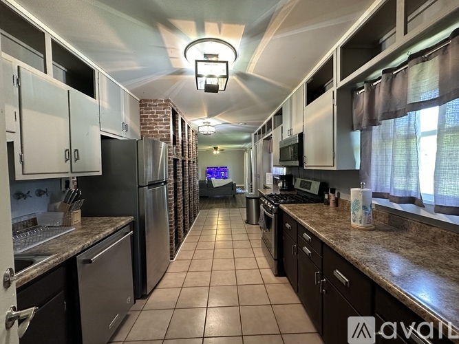 A kitchen with brown countertops and a tile floor.
