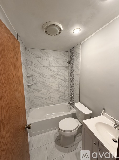 A bathroom with a toilet, sink, and bathtub.