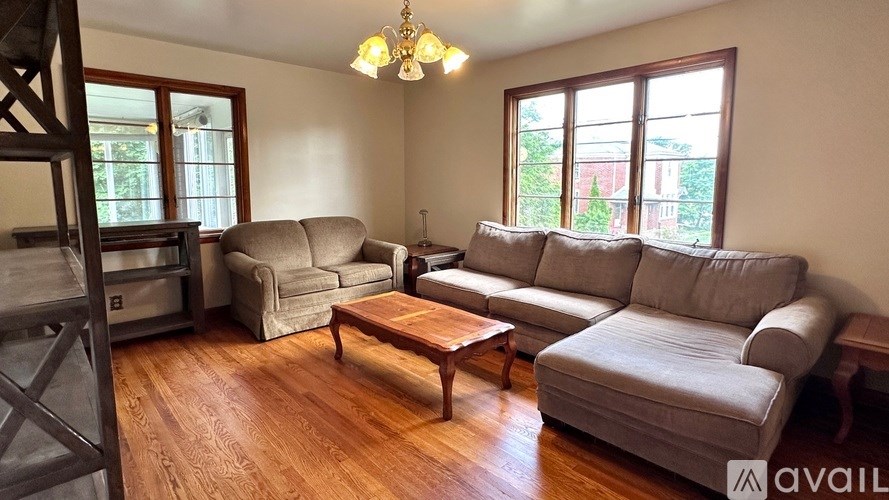 A living room with wooden floors and a large grey sectional sofa.