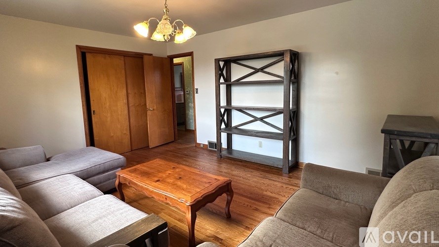 A living room with a couch, a coffee table, and a large window.