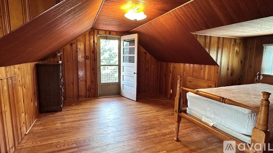 A bedroom with wooden walls and a bed in the center.