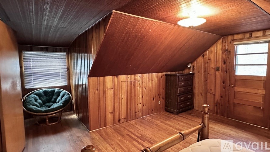 A room with wooden walls and a window with blinds.