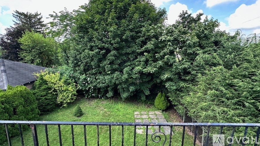 A lush green garden with a fence in the foreground.