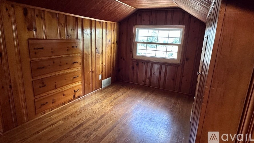 A wooden room with a window and drawers.