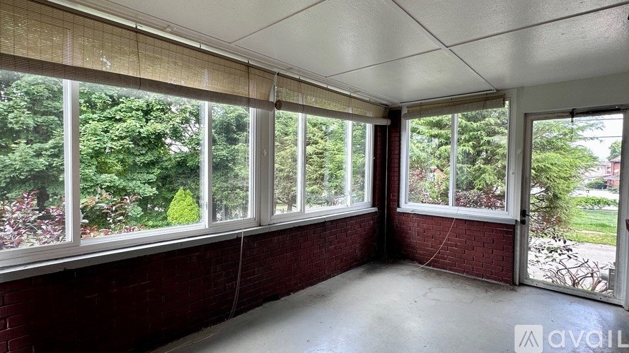 A room with large windows and a view of greenery outside.