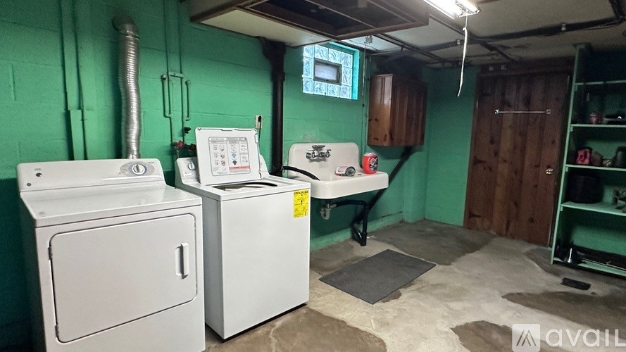 A room with a washing machine and a dryer.