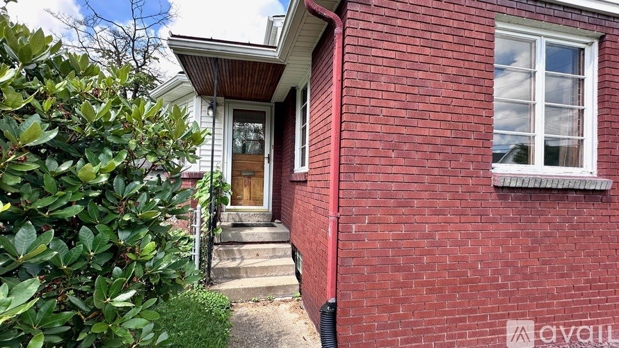 A red brick house with a white window and a wooden door.