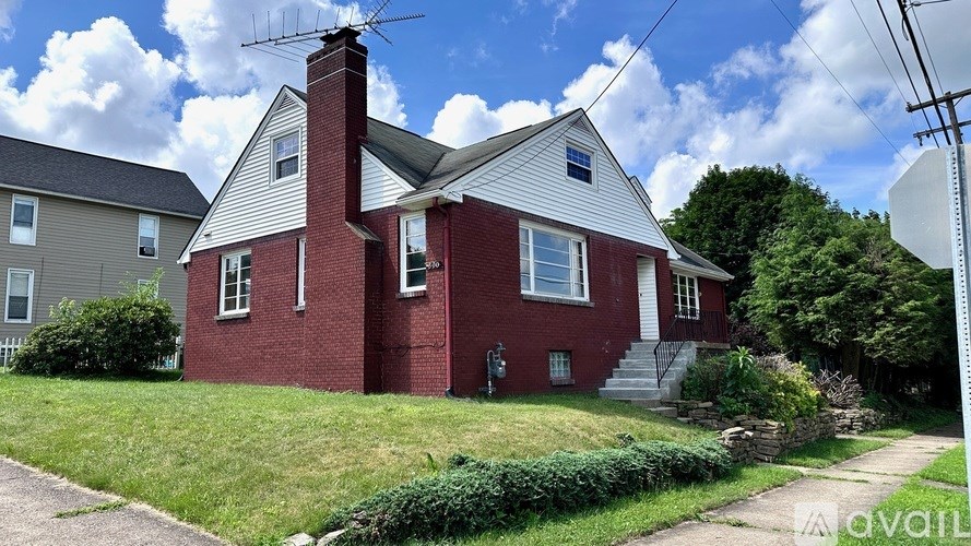 A red brick house with a white roof and a chimney.