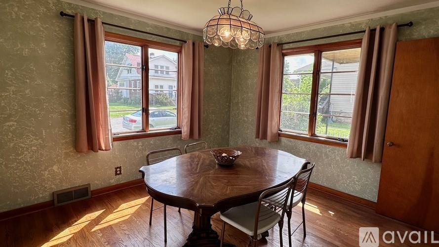 A dining room with a round table and chairs.