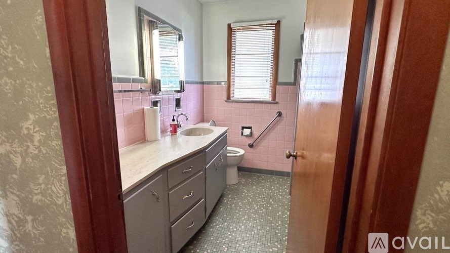 A bathroom with a toilet, sink, and mirror.