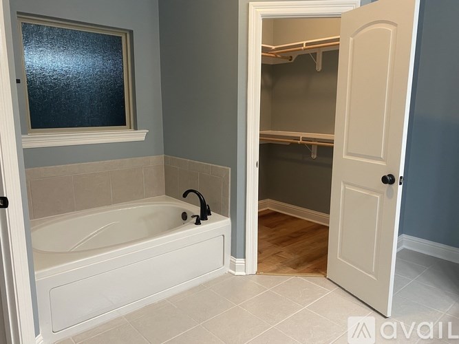 A bathroom with a white bathtub and a white door.