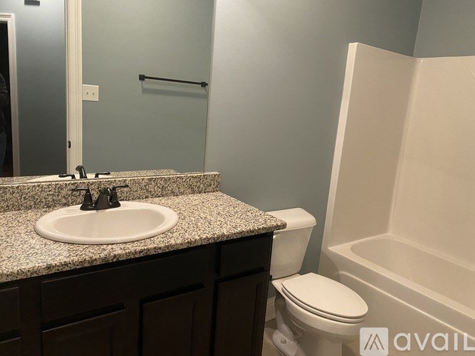 A bathroom with a sink, toilet, and bathtub.