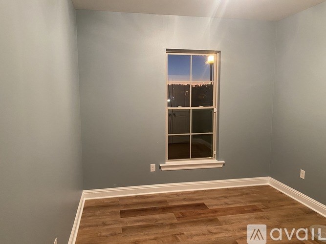 A room with a window showing a cityscape at dusk.