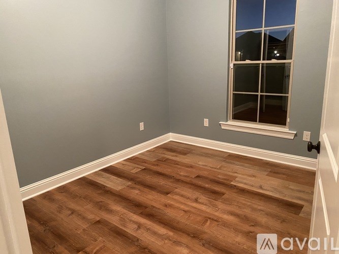 A room with wooden flooring and a window.